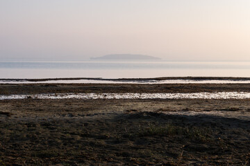 Beach at Trasimeno lake Umbria, with water stripes and island on the background - 610759187