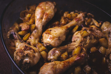 Chicken thighs with baked potatoes on a dark background