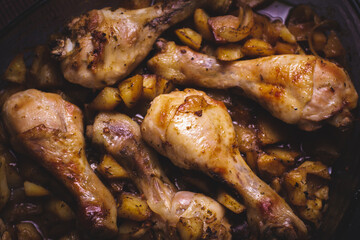 Juicy and tender chicken thighs with baked potatoes, homemade dinner.