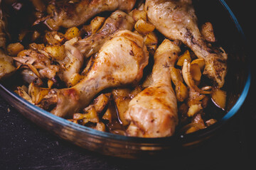 Main course roasted chicken thighs on a dark background, High contrast image of tasty chicken. Homemade food.
