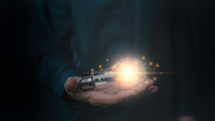 hand and light bulb. idea concept with innovation and inspiration, Innovative idea in businessman, illuminated light bulb. idea, innovation, thinking, and inspiration for business digital data idea.