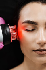 Red light of thermal or radio frequency on face of young woman for hardware RF lifting. Tightening...
