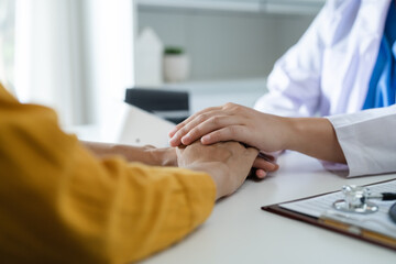 Doctor comforting taking care of the patient by hold hand.
