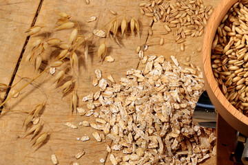 Haferkörner, Haferflocken, Haferähren mit Flocker auf altem Backbrett