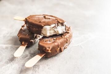 Popsicle, ice cream covered with chocolate on kitchen table.