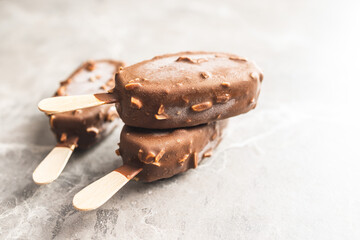 Popsicle, ice cream covered with chocolate on kitchen table.