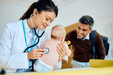 Female pediatrician and baby during medical examination at doctor's office.