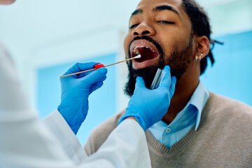 African American man during throat examination at doctor's office.