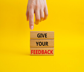 Feedback symbol. Concept word Give your feedback on wooden blocks. Businessman hand. Beautiful yellow background. Business and Ask for feedback concept. Copy space