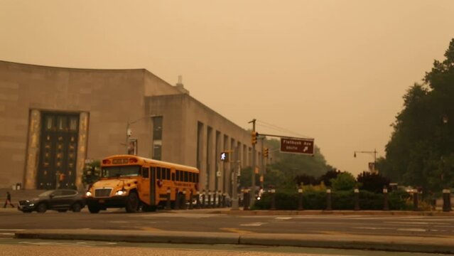time lapse of cars, pedestrians, cyclists passing brooklyn public library with smoke in the air (smog, pollution from wildfires in nyc) central air quality haze at grand army plaza