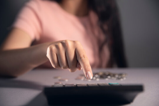 women holding a coins and press calkulator