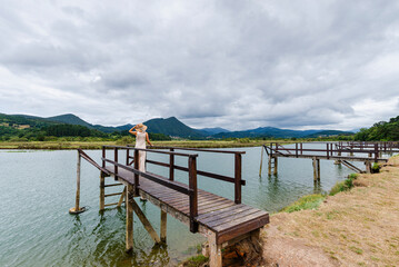 Obraz premium Woman on wooden pier of Murueta in Urdaibai biosphere reserve, Biscay, Basque Country, Spain