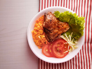 
Styrofoam lunch box with roasted chicken and salad and farofa on the table and towel and with space for text 