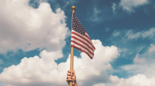Hand Holding an American Flag on a Wooden Flag Pole up Against a Blue Sky with Clouds - Muted Surrealism Tones - Patriotic American Red, White, and Blue - 4th of July USA Theme - Generative AI