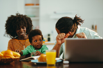 A contemporary african american family at the breakfast table in the morning.