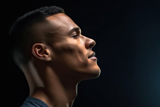 portrait of a young black man in profile on a black background