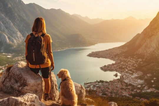 Woman and her beloved dog as they stand on the peak of a mountain. Generative AI