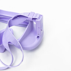 Lilac diving and snorkeling mask on white background. Rubber strap closeup