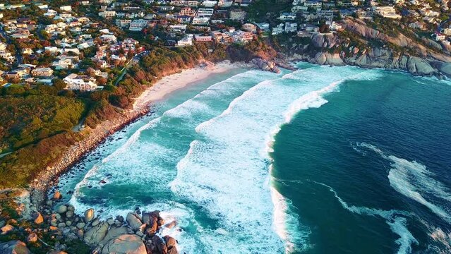 Aerial View, Ocean And Waves With Property Buildings On The Coast Of Architecture Or Natural Environment. Drone, Beach And Water Of Seashore By Urban Town, City Or Neighborhood Houses In Nature