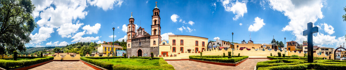 Fototapeta na wymiar panoramic view of yellow church and catholic cross in a garden in el oro de hidalgo, state of mexico 