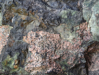 Texture of a colorful glossy natural stone as an abstract black, pink and green background