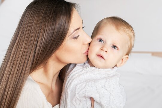 Happy young Mother Kissing cute Baby