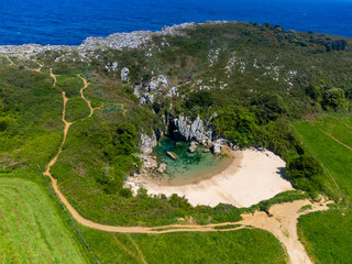 Aerial view, Playa de Gulpiyuri, flooded sinkhole with inland beach near Llanes, in Asturias...