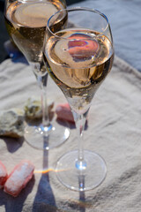 Tasting of grand cru sparkling rose wine with bubbles champagne with view on old houses of Oger, small village with grand cru vineyards, France.