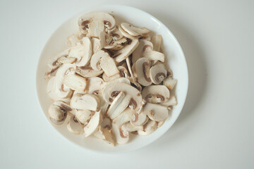Fresh champignons mushroom in a white bowl on table 