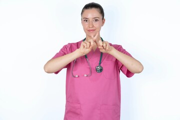 young caucasian doctor woman wearing pink uniform over white background has rejection angry...