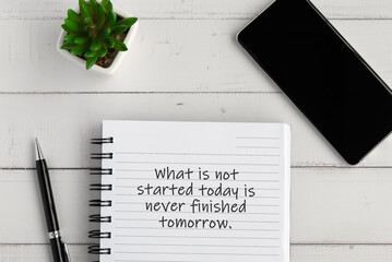 Fototapeta na wymiar Notepad with inspirational text - What is not started today is never finished tomorrow.