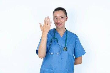 young caucasian doctor woman wearing medical uniform over white background smiling and looking friendly, showing number five or fifth with hand forward, counting down