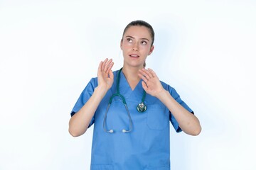young caucasian doctor woman wearing medical uniform over white background keeps palms forward and...
