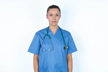 Displeased young caucasian doctor woman wearing medical uniform over white background frowns face feels unhappy has some problems. Negative emotions and feelings concept