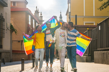 Lifestyle of embraced homosexual friends walking at the gay pride party in the city, diversity of...