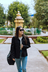 Portrait photo of young woman with sunglasses smiling outdoors. Concept of people and lifestyle.