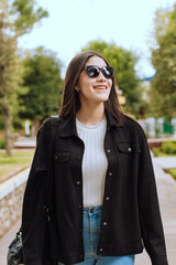 Portrait photo of young woman with sunglasses smiling outdoors. Concept of people and lifestyle.