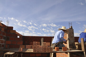 pedreiro construtor edificando parede de tijolos em obra 