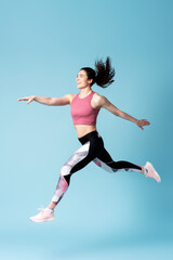 Fototapeta na wymiar Cheerful female jogger, active competitive determined sportswoman jumping high
