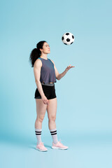 Fototapeta na wymiar Successful female athletic woman, soccer player, standing alone playing with soccer ball