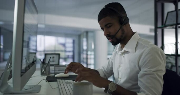 Night, telemarketing and black man with call center, computer and business with headphones, explain system and consultation. Male person, employee or agent with tech support, crm and customer service