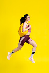 Active competitive determined sportswoman jumping high, jogging marathon
