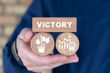 Man holding wooden blocks with inscription: VICTORY. Concept of business victory. Trophy, champions award, sport victory. Competition success, first place, best win, celebration.