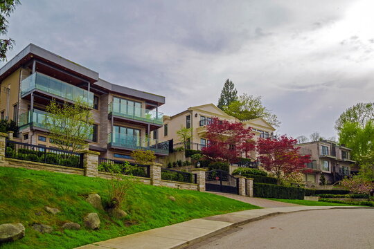 Residential district in the Burnaby Lake Park area, private houses with sundecks, trees and garden on the background of blue cloudy sky