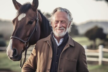 Medium shot portrait photography of a grinning man in his 60s that is wearing a chic cardigan against an equestrian or horse background .  Generative AI