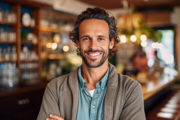 Fototapeta premium Portrait of handsome man smiling at camera in a pub or restaurant