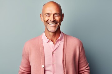Medium shot portrait photography of a grinning man in his 40s that is wearing a chic cardigan against a pastel or soft colors background .  Generative AI