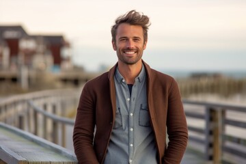 Obraz premium Portrait of a handsome man standing on a pier at the beach