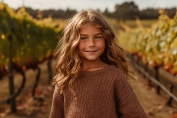 Obraz premium Portrait of a cute little girl in a vineyard in autumn