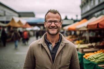 Fototapeta premium Medium shot portrait photography of a pleased man in his 40s that is wearing a chic cardigan against a bustling farmer's market background . Generative AI
